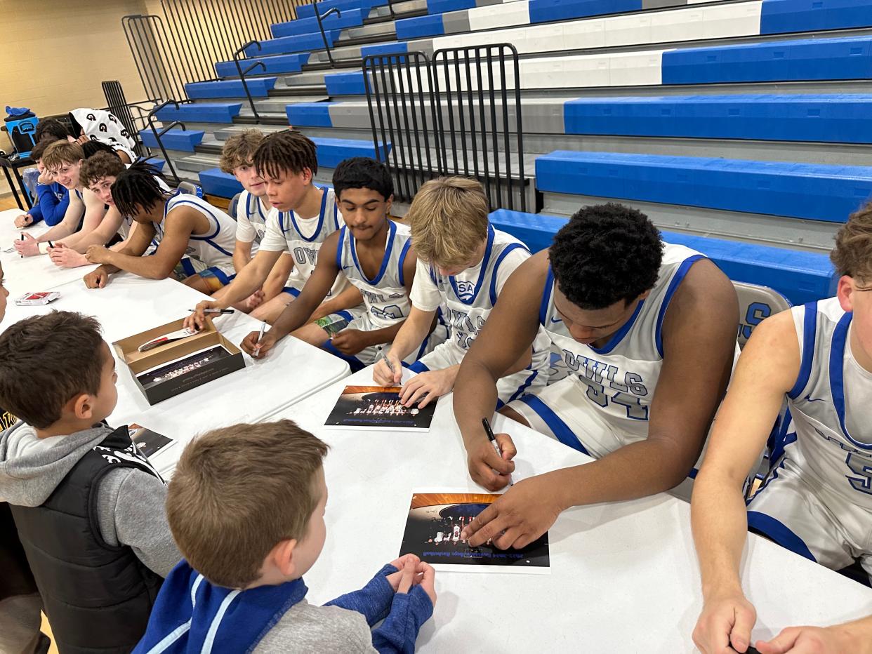 Bensalem boys basketball players sign autographs for young fans after a Nov. 27 win over Norristown.