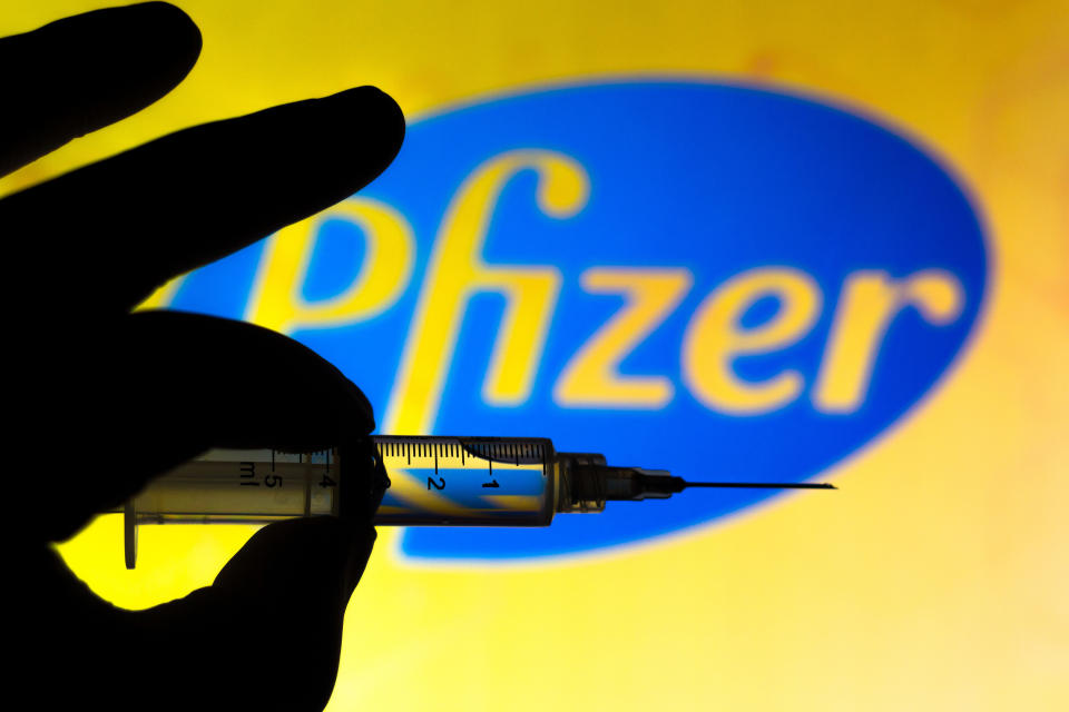 BRAZIL - 2020/11/13: In this photo illustration the medical syringe is seen with Pfizer company logo displayed on a screen in the background. (Photo Illustration by Rafael Henrique/SOPA Images/LightRocket via Getty Images)