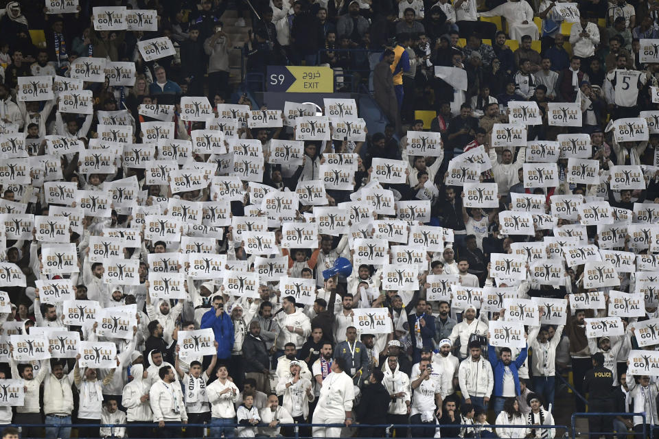 Real Madrid's fans raise goal signs during the Spanish Super Cup semi final soccer match between Real Madrid and Atletico Madrid at Al Awal Park Stadium in Riyadh, Saudi Arabia, Wednesday, Jan. 10, 2024. (AP Photo)