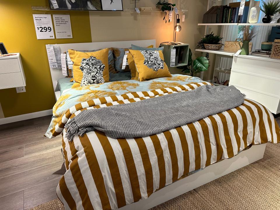 Bed with striped, yellow, and blue bedding at Ikea