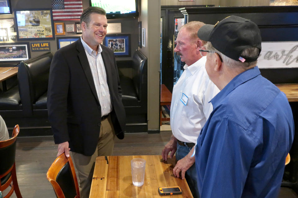 Kris Kobach, left, a Republican candidate for the U.S. Senate in Kansas, speaks with supporters Bill Vonderschmidt, center, and Bob Sines, both from Hiawatha, Kan., Wednesday, July 29, 2020, during a meet-and-greet event in Holton, Kan. Kobach is locked in a tight race with western Kansas Rep. Roger Marshall for the GOP nomination. (AP Photo/John Hanna)