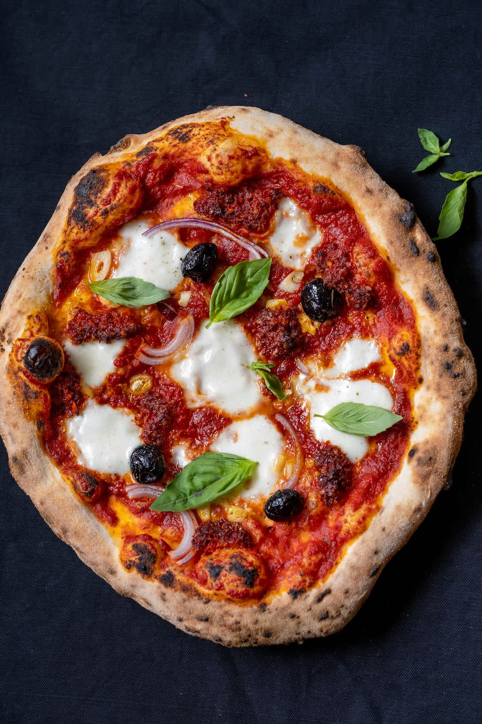 pizza with tomato sauce, mozzarella, nduja, olives, and garlic
