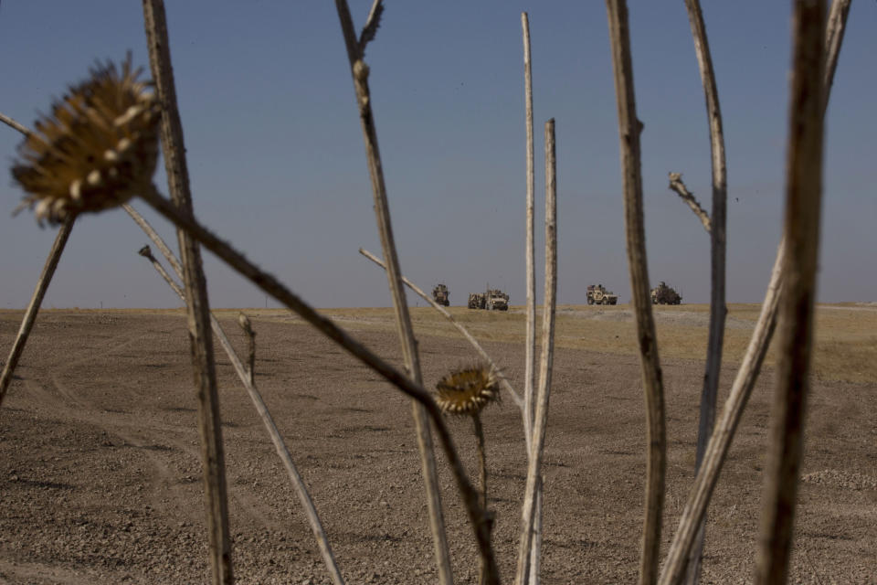 U.S. armored vehicles stage on a hilltop before a joint patrol with Turkish forces as they conduct their first joint ground patrol in the so-called "safe zone" on the Syrian side of the border with Turkey, seen in the background, near Tal Abyad, Syria, Sunday, Sept. 8, 2019. Turkey hopes the buffer zone, which it says should be at least 30 kilometers (19 miles) deep, will keep Syrian Kurdish fighters, considered a threat by Turkey but U.S. allies in the fight against the Islamic State group, away from its border. (AP Photo/Maya Alleruzzo)