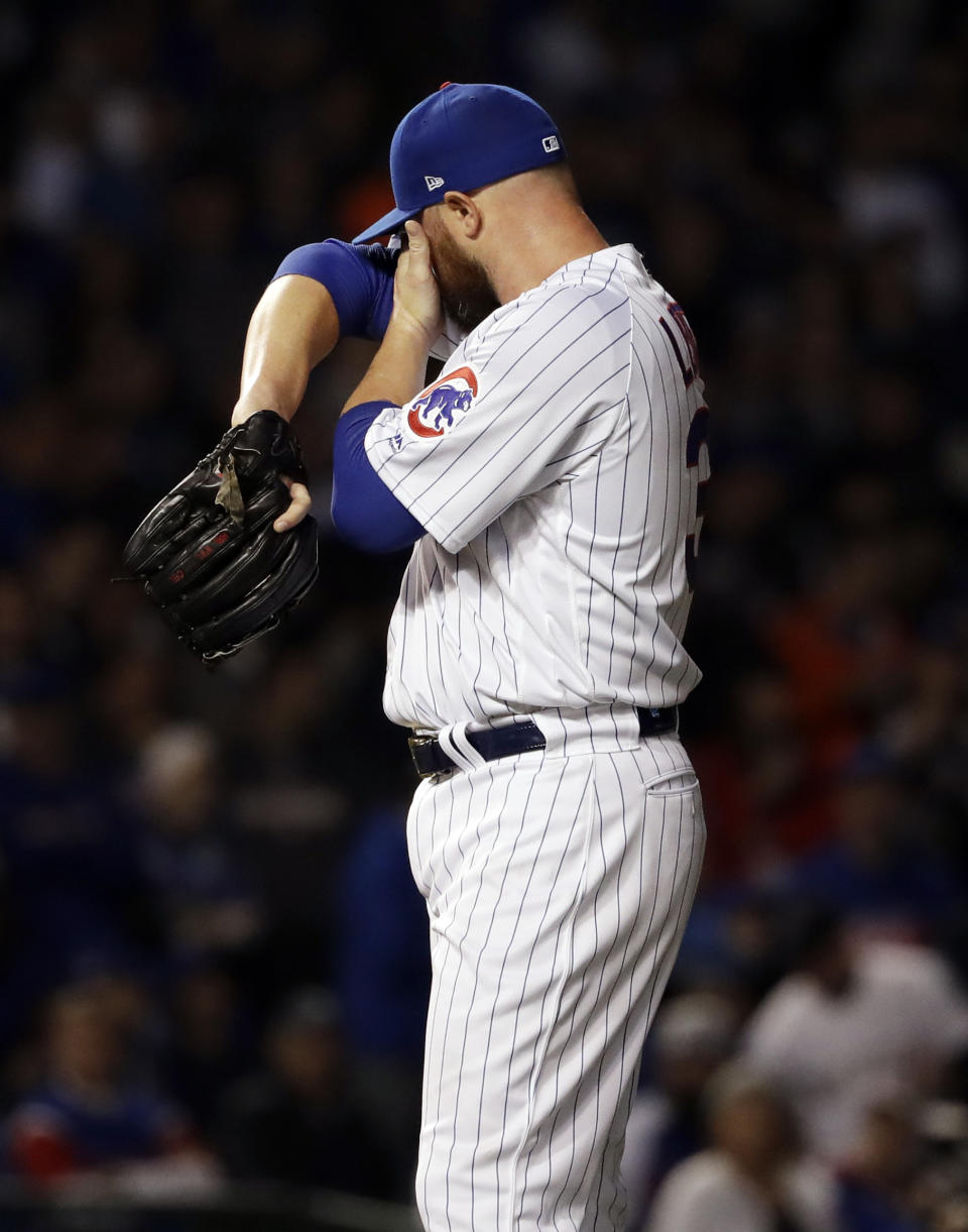 Chicago Cubs starting pitcher Jon Lester wipes his face after Colorado Rockies' DJ LeMahieu hit a ground-rule double during the first inning of the National League wild-card playoff baseball game Tuesday, Oct. 2, 2018, in Chicago. (AP Photo/Nam Y. Huh)