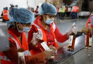 Workers prepare to pack whisky bottles inside Piccadily Distilleries in Indri