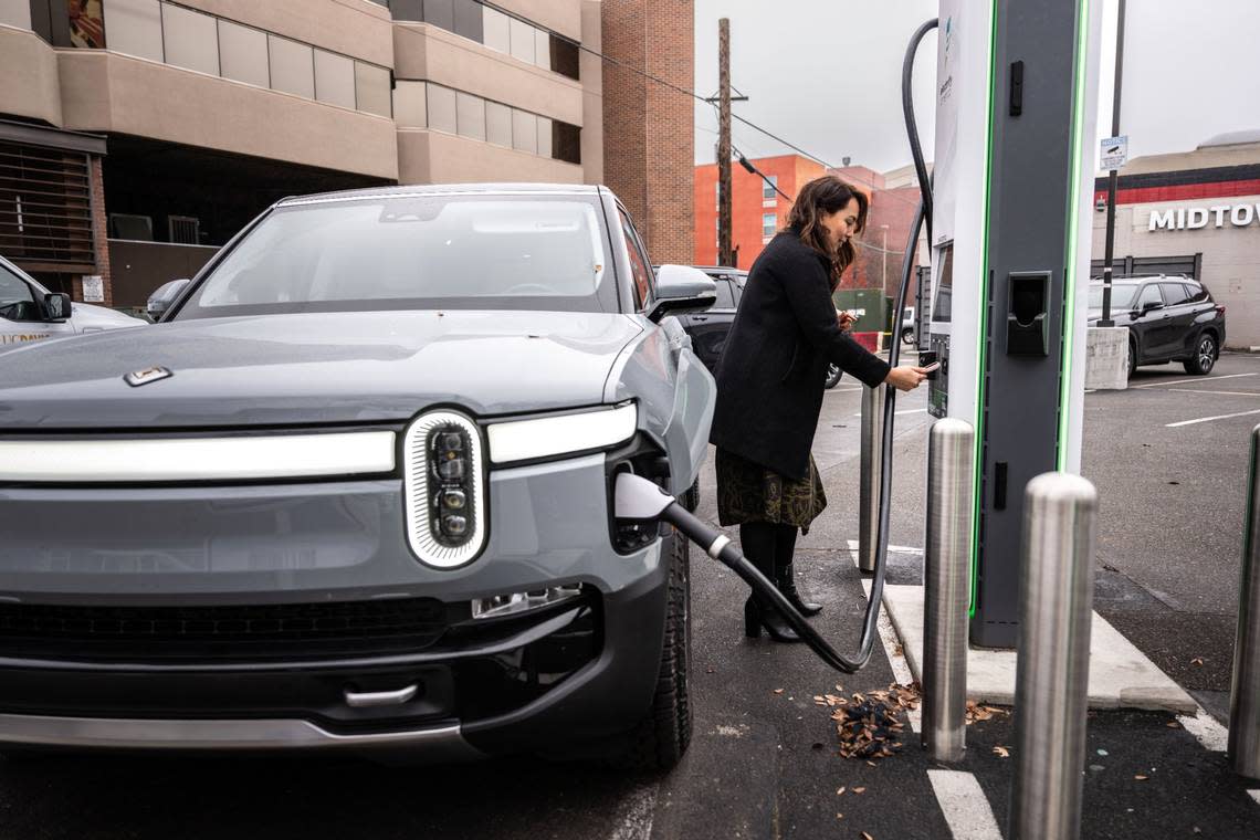 Sacramento resident Angie Manetti charges her car earlier this month at an Electrify America station in downtown Sacramento. Manetti, like many new electric car owners, said she experienced a learning curve as she navigated the different public charging stations.