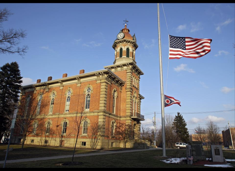 Flags fly at half staff in front of the town hall in Chardon, Ohio for the victims of an early morning school shooting on Feb. 27, 2012. A gunman opened fire inside the high school's cafeteria at the start of the school day, killing three students and wounding two others. 