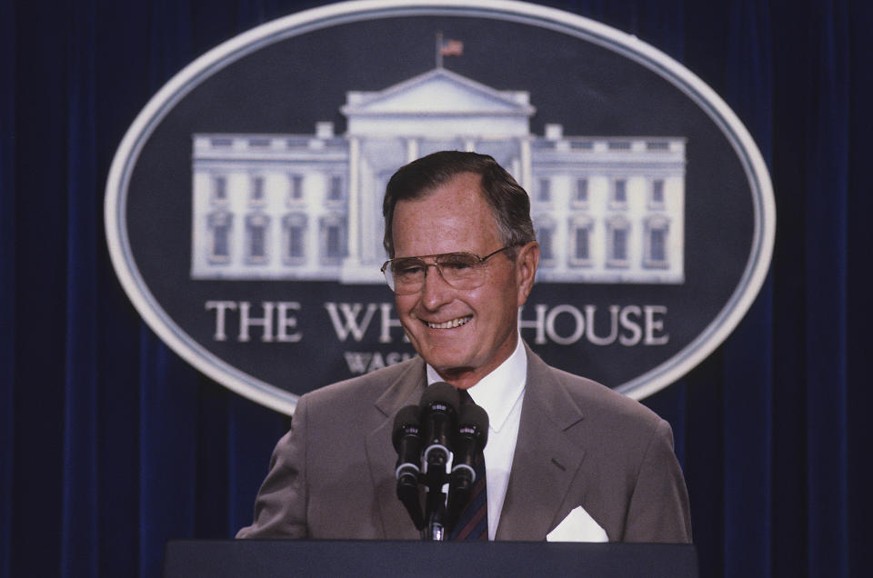 Late President George H. W. Bush stands at the podium as he responds to reporters questions during a news conference in the press briefing room at the White House in 1990. Credit: Mark Reinstein Credit: Mark Reinstein/MediaPunch /IPX