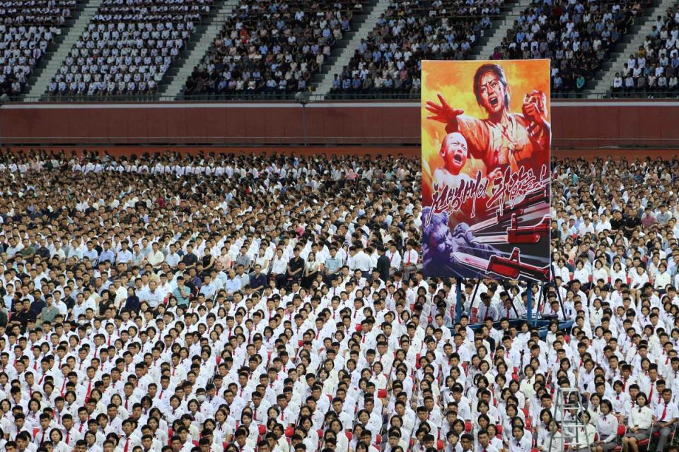 People take part in a mass rally to mark what North Korea calls 