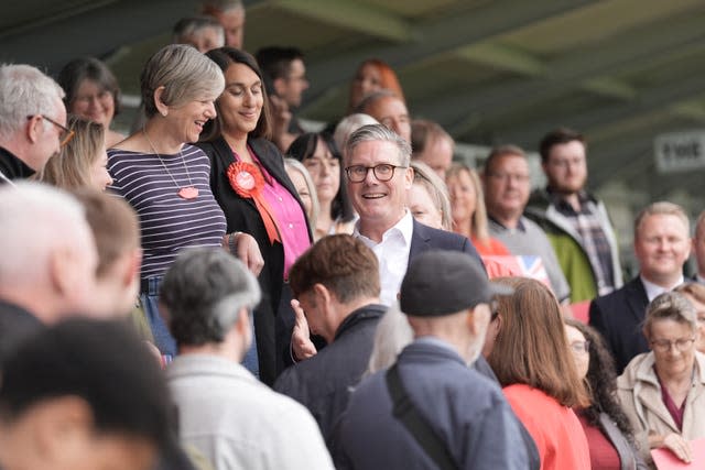 Sir Keir Starmer surrounded by supporters at a football club