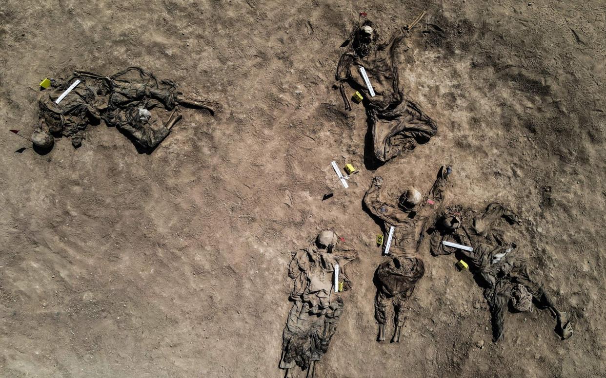 Graphic content: This aerial view taken on June 13, 2021, shows human remains, reportedly of victims of the 2014 Badush prison massacre committed by the Islamic State (IS) group, after being unearthed from a mass grave in the northern Iraqi village of Badush, northwest of the city of Mosul. - In June 2014, IS fighters attacked the prison, freeing Sunnis and loading the remaining 600 mainly Shiite inmates onto trucks, before driving them to a ravine and shooting them. - ZAID AL-OBEIDI/AFP