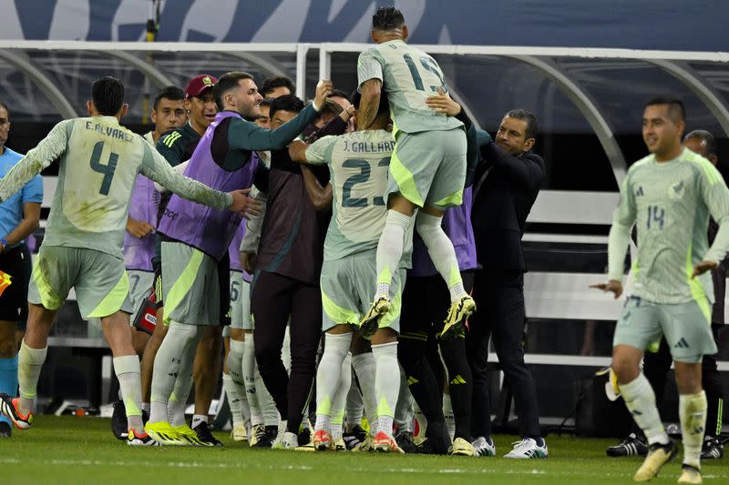 Jugadores de México celebran con el cuerpo técnico tras anotar uno de los tres goles con los que ganaron a Panamá en la semifinal de la Liga de Campeones de la Concacaf