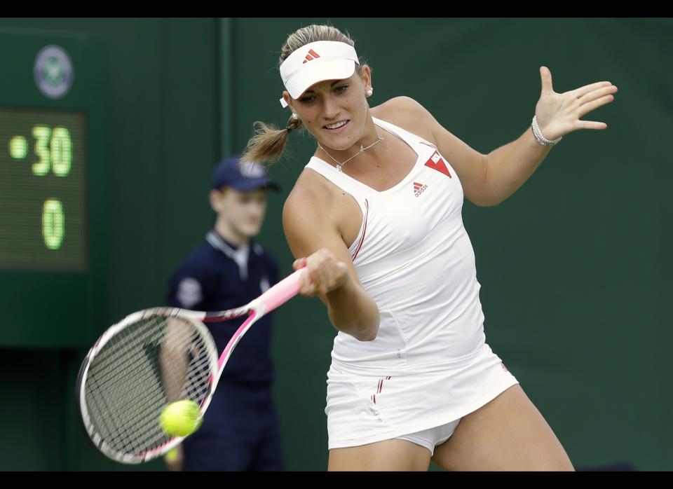 Timea Babos of Hungary returns a shot to Melanie Oudin of the United States during a first round women's singles match at the All England Lawn Tennis Championships at Wimbledon, England, Monday, June 25, 2012. 