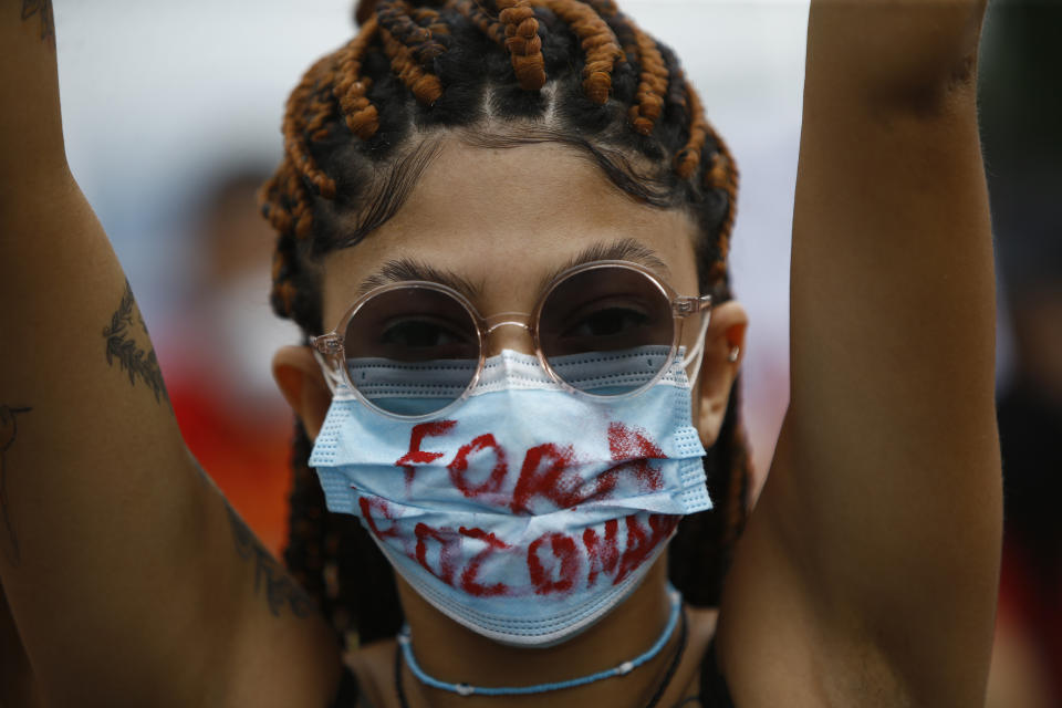 A woman wearing a protective face mask marked with a message that reads in Portuguese: "Get Out Bolsonaro" during a protest against Brazilian President Jair Bolsonaro's handling of the coronavirus pandemic and economic policies they say harm the interests of the poor and working class, in Rio de Janeiro, Brazil, Saturday, June 19, 2021. Brazil is approaching an official COVID-19 death toll of 500,000 — second-highest in the world. (AP Photo/Bruna Prado)