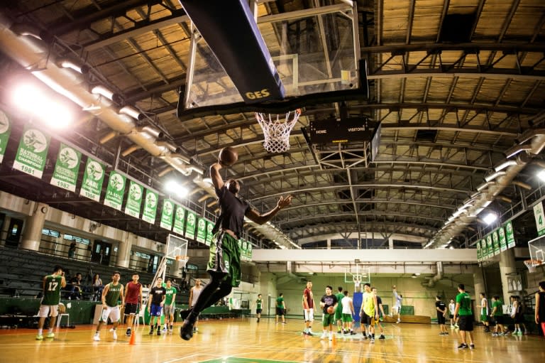 Cameroon's Benoit Mbala attempts a dunk during basketball practice at De La Salle University's gym in Manila on January 24, 2017