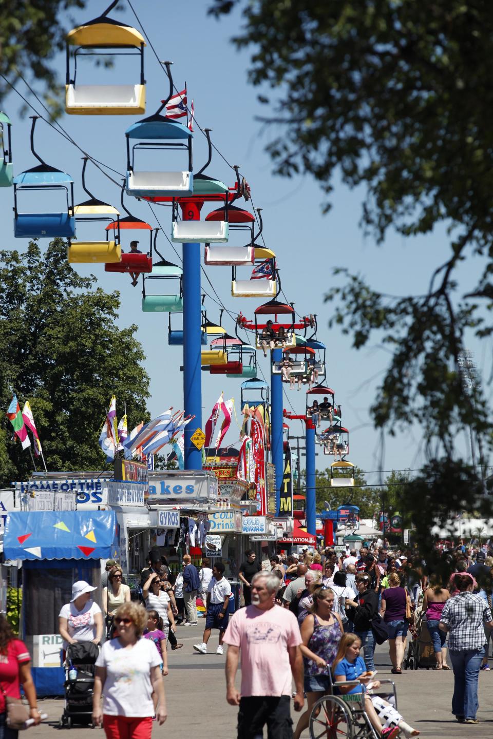 Crowds of people walk through the row of food vendors at the Ohio State Fair.