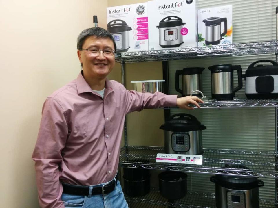 Inventor and former Nortel engineer Robert Wang poses with some Instant Brands products. The company formed when Wang merged his shop with Illinois-based Corelle Brands in 2019.  (Idil Mussa/CBC - image credit)