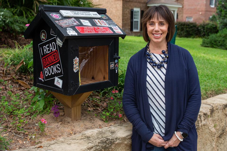 Heather Encinosa stocks her “little free library,” located in Betton Hills, with banned books, giving the public access to reading books that have been banned in Florida schools.