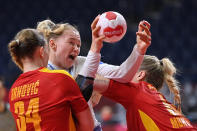 <p>Russia's pivot Kseniia Makeeva (C) is challenged during the women's quarterfinal handball match between Montenegro and Russia of the Tokyo 2020 Olympic Games at the Yoyogi National Stadium in Tokyo on August 4, 2021. (Photo by Fabrice COFFRINI / AFP)</p> 