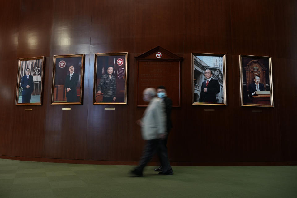 A pro-China lawmakers walks past portraits of the former presidents of the Legislative Council before the second meeting of "Improving Electoral System (Consolidated Amendments) Bill 2021" at the Legislative Council in Hong Kong Thursday, May 27, 2021. Hong Kong’s legislature on Thursday moved closer towards amending electoral laws that would drastically reduce the public’s ability to vote for lawmakers and increase the number of pro-Beijing lawmakers making decisions for the city. (AP Photo/Vincent Yu)