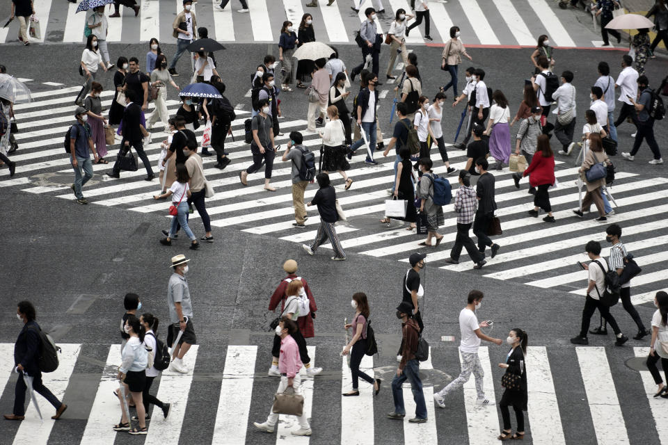 People wearing a protective face mask to help curb the spread of the coronavirus walk at Shibuya pedestrian crossing Thursday, July 9, 2020, in Tokyo. The Japanese capital has confirmed more than 220 new coronavirus infections, exceeding its previous record.(AP Photo/Eugene Hoshiko)