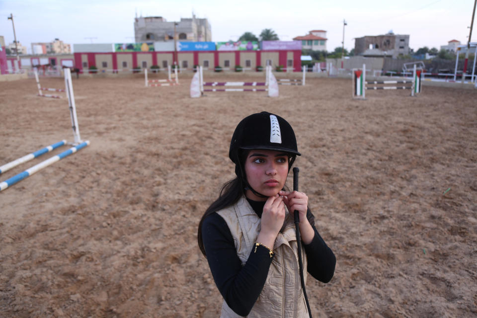 Fatma Youssef, 17, a Palestinian high school student and a horse rider, adjusts her helmet as she prepares to ride a horse at an equestrian club, in Gaza City, Dec.  9, 2018. "I'm nervous because this is my final high school year, but when I ride my horse I become free of stress," Youssef said. (Photo: Samar Abo Elouf/Reuters)   