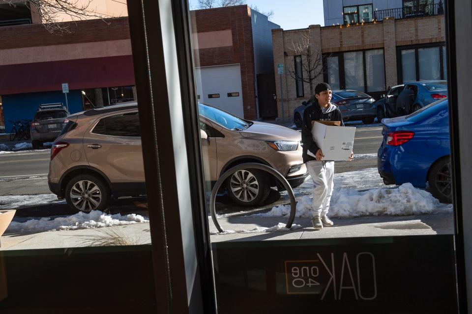 An individual carries a box into a new apartment building, Oak 140, on Thursday in downtown Fort Collins. The 79-unit building, a partnership between Housing Catalyst and the Downtown Development Authority, is the first low-income housing tax credit project designed for workers in downtown.