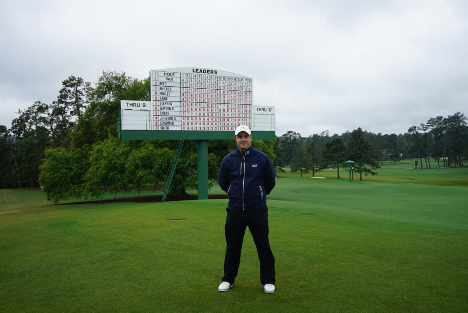 Tom Clarke at The Masters in front of the leaderboard on 18