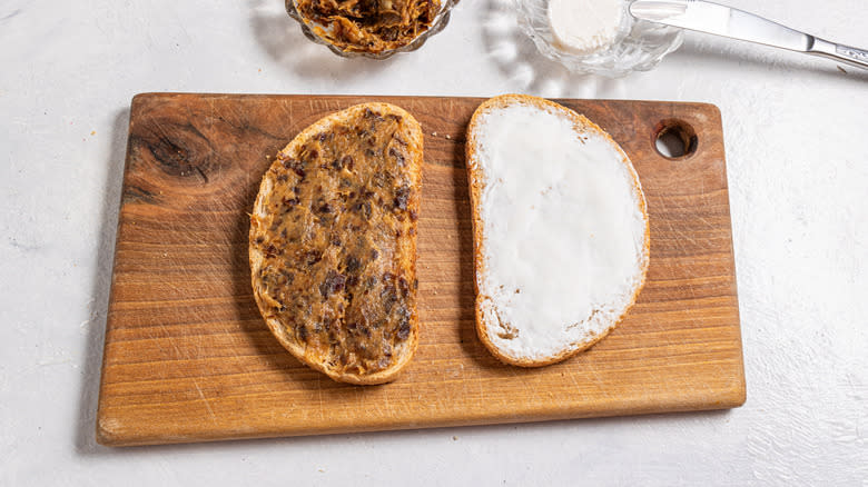 Two slices of bread, one with goat cheese, one with mashed dates
