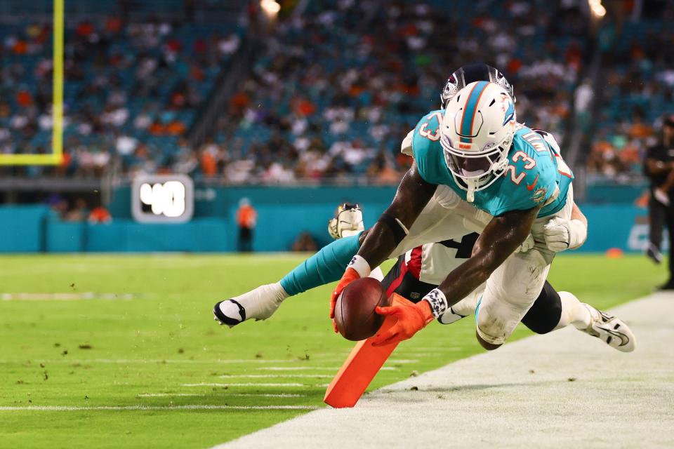 Aug 9, 2024; Miami Gardens, Florida, USA; Miami Dolphins running back Jeff Wilson Jr. (23) scores a touchdown against Atlanta Falcons linebacker JD Bertrand (40) during the second quarter at Hard Rock Stadium. Mandatory Credit: Sam Navarro-USA TODAY Sports