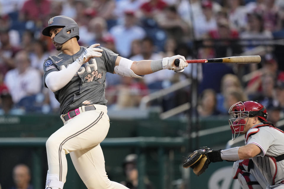 Washington Nationals' Joey Meneses singles in front of Philadelphia Phillies catcher J.T. Realmuto in the second inning of a baseball game, Friday, June 2, 2023, in Washington. Jeimer Candelario scored on the play. (AP Photo/Patrick Semansky)