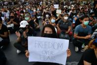 A protester holds a sign during a protest demanding the resignation of the government in Bangkok