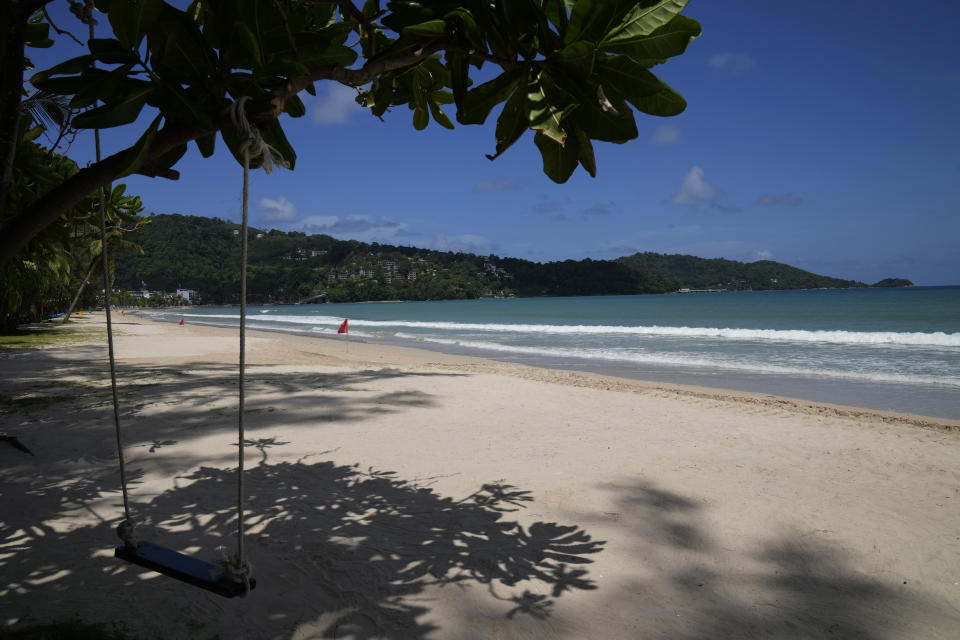 An empty swing hangs from a tree on the empty tourist beach of Patong on Phuket, southern Thailand, Monday, June 28, 2021. Thailand's government will begin the "Phuket Sandbox" scheme to bring the tourists back to Phuket starting July 1. Even though coronavirus numbers are again rising around the rest of Thailand and prompting new lockdown measures, officials say there's too much at stake not to forge ahead with the plan to reopen the island to fully-vaccinated travelers. (AP Photo/Sakchai Lalit)
