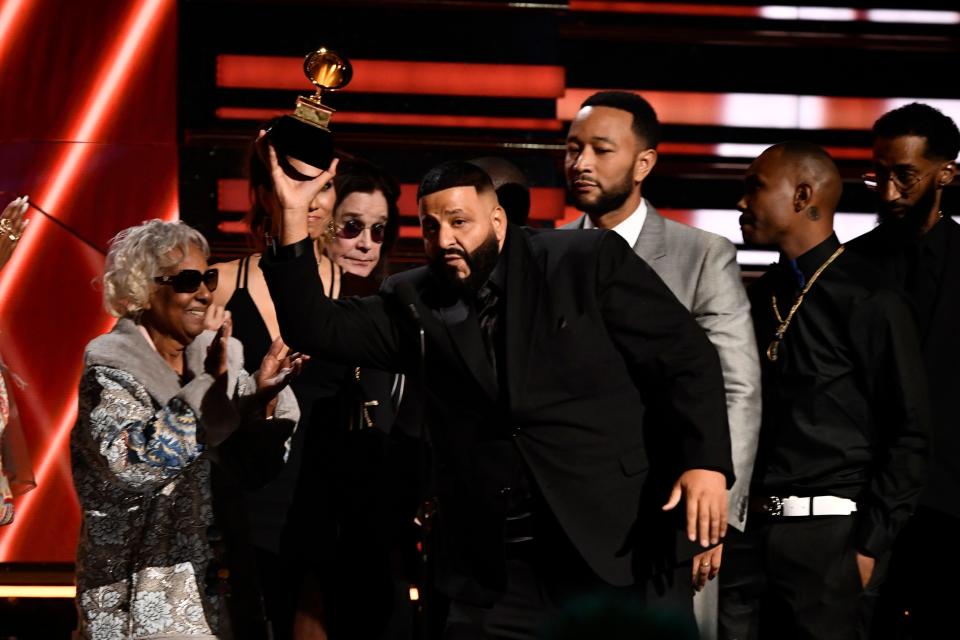 DJ Khaled (center) and John Legend (right) accept the award for best rap/sung performance and honor their late collaborator Nipsey Hussle at the Grammy Awards.
