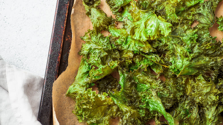 kale chips on parchment paper-lined baking sheet