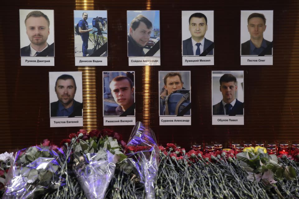 Flowers and tributes in front of portraits of Russian TV journalists who were abord the crashed military plane. Photo: AP