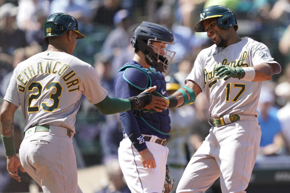 Oakland Athletics' Elvis Andrus (17) greets Christian Bethancourt (23) at the plate after Andrus hit a two-run home run to score Bethancourt during the sixth inning of a baseball game against the Seattle Mariners, Wednesday, May 25, 2022, in Seattle. (AP Photo/Ted S. Warren)