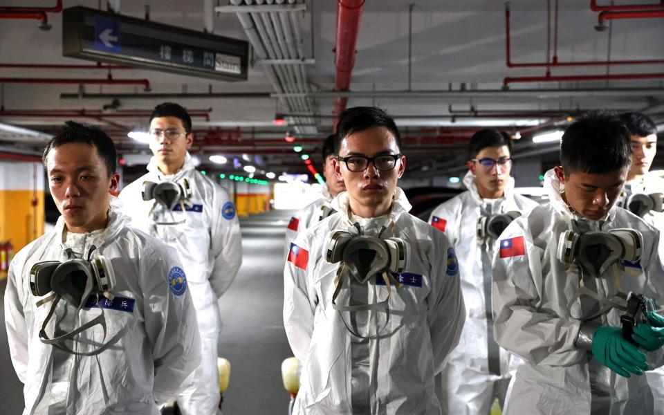 Soldiers prepare to spray disinfectant at the Taoyuan General Hospital - Reuters