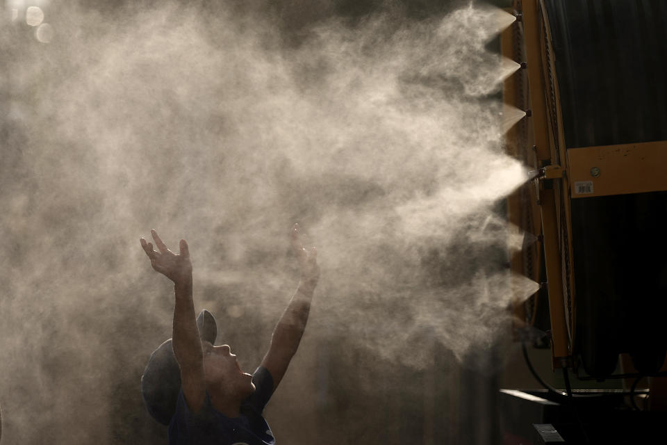 Lucas Harrington, age 7, cools off in a mister at Kauffman Stadium as temperatures approach 100 degrees fahrenheit before a baseball game between the Kansas City Royals and the Cleveland Guardians, Wednesday, June 28, 2023, in Kansas City, Mo. The entire planet sweltered for the two unofficial hottest days in human recordkeeping Monday and Tuesday, according to University of Maine scientists at the Climate Reanalyzer project. The unofficial heat records come after months of unusually hot conditions due to climate change and a strong El Nino event. (AP Photo/Charlie Riedel)