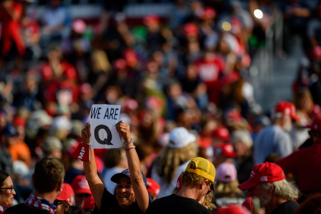 A woman holds up a QAnon sign to the media as attendees wait for President Donald Trump to speak at a Sept. 22 campaign rally at Atlantic Aviation in Moon Township, Pennsylvania. (Photo: Jeff Swensen via Getty Images)