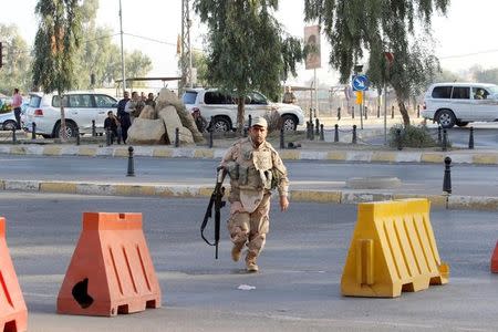 A member of peshmerga forces runs at a site of an attack by Islamic State militants in Kirkuk, Iraq, October 21, 2016. REUTERS/Ako Rasheed