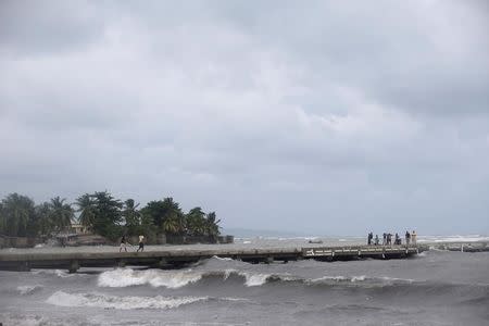 Residents stand on a pier ahead of Hurricane Matthew in Les Cayes, Haiti, October 2, 2016. REUTERS/Andres Martinez Casares