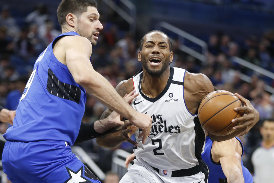 Los Angeles Clippers forward Kawhi Leonard (2) works the ball around Orlando Magic center Nikola Vucevic (9) during the first quarter of an NBA basketball game in Orlando, Fla., Sunday, Jan. 26, 2020. (AP Photo/Reinhold Matay)