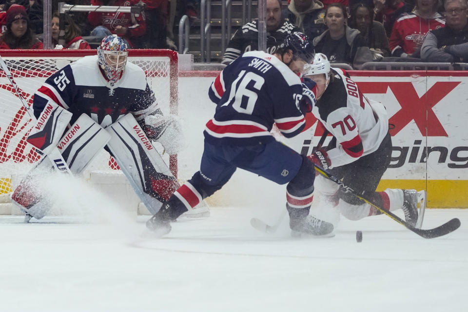 Washington Capitals center Craig Smith (16) and New Jersey Devils center Jesper Boqvist (70) battle for the puck with Washington Capitals goaltender Darcy Kuemper (35) nearby in the first period of an NHL hockey game, Thursday, March 9, 2023, in Washington. (AP Photo/Alex Brandon)