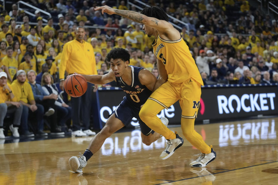 Virginia guard Kihei Clark (0) drives on Michigan guard Jaelin Llewellyn (3) in the first half of an NCAA college basketball game in Ann Arbor, Mich., Tuesday, Nov. 29, 2022. (AP Photo/Paul Sancya)