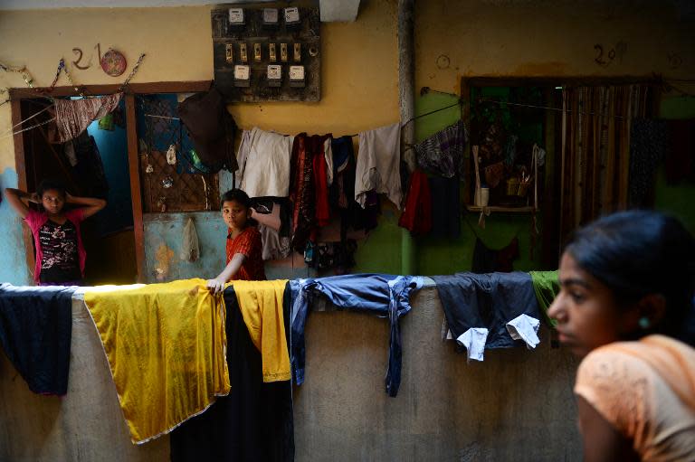 Indian residents walk past the home of Mohammad Awwal, 18, who is suffering from dengue fever in New Delhi, on October 2, 2013