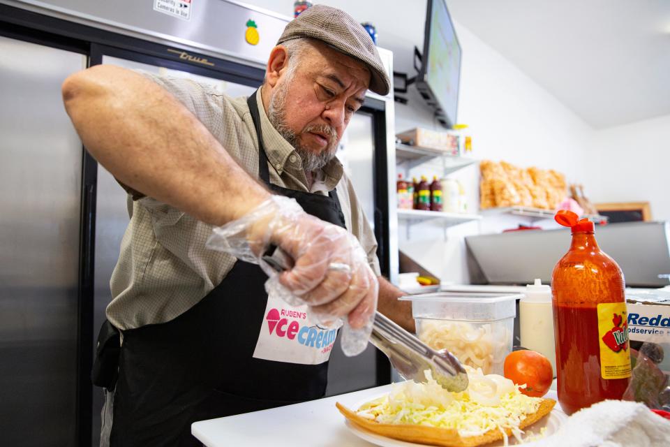 Jesus Fuentes adds cabbage to a chicharron preparado at Ruben's Ice Cream y Antojitos Mexicanos on Thursday, March 21, 2024, in Keizer, Ore.