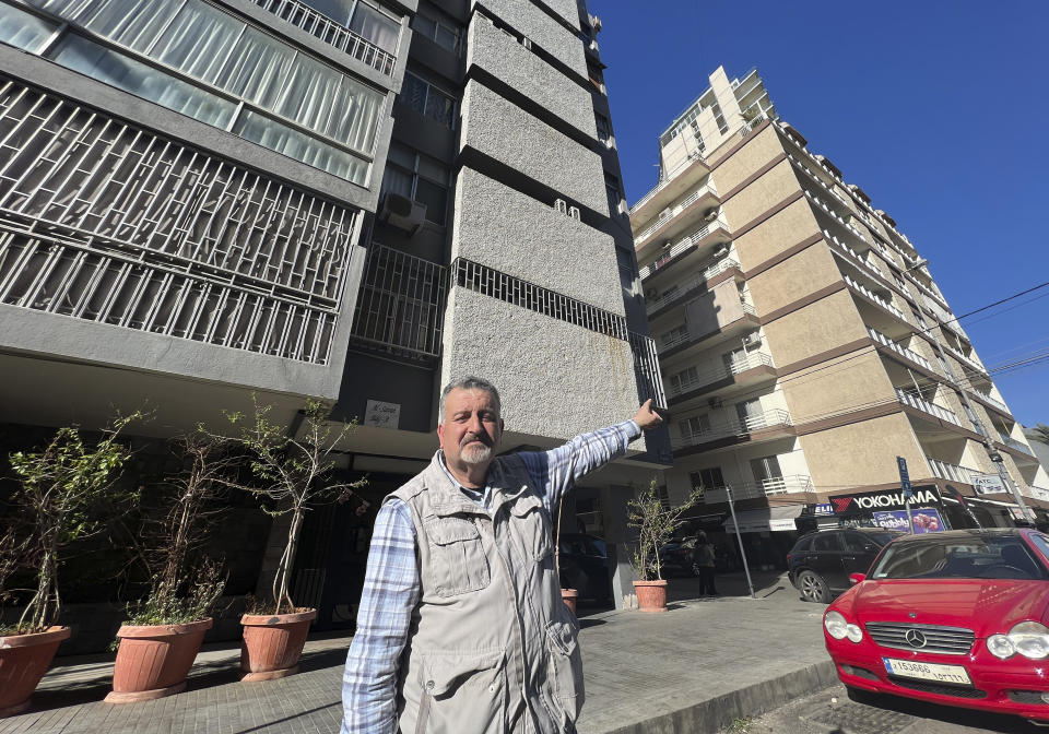 Lebanese writer Ziad Kaj, whose latest book released in January 2023 has a small chapter about the Israeli raid in 1973, points to one of the building where three top officials with the Palestine Liberation Organization were killed by Israeli forces in April 10, 1973, in Beirut, Lebanon, Tuesday, April 4, 2023. The Israeli commando force led by a man disguised as brunette, Ehud Barak, who later rose to become Israel's prime minister infiltrated a posh Beirut neighborhood shooting dead three top officials with the Palestine Liberation Organization in two separate adjacent buildings. (AP Photo/Hussein Malla)