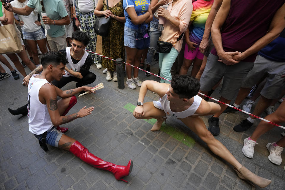 Participants stretch before competing in the Pride Week annual high heels race in the Chueca district, a popular area for the gay community in Madrid, Spain, Thursday, July 4, 2024. (AP Photo/Paul White)