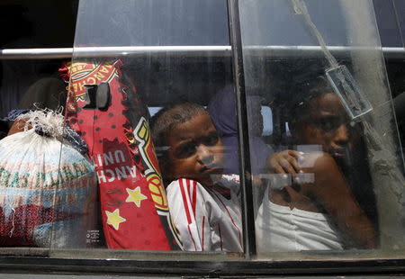 Children, who are part of a group of Rohingya and Bangladeshi migrants who arrived in Indonesia by boat this week, leave a temporary shelter for new accommodation in Lhoksukon, Indonesia's Aceh Province May 13, 2015. REUTERS/Roni Bintang